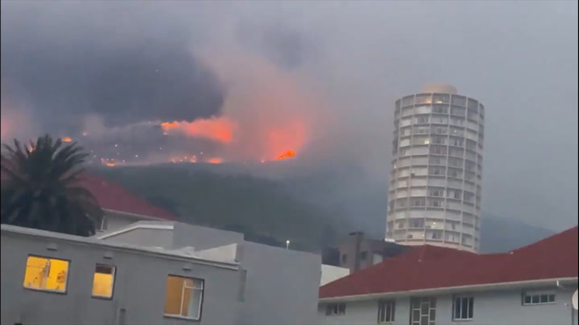 A fire that broke out on Sunday morning in the foothills of South Africa's iconic Table Mountain continued burning on Monday, destroying buildings and forcing evacuations as firefighters struggled against strong winds.