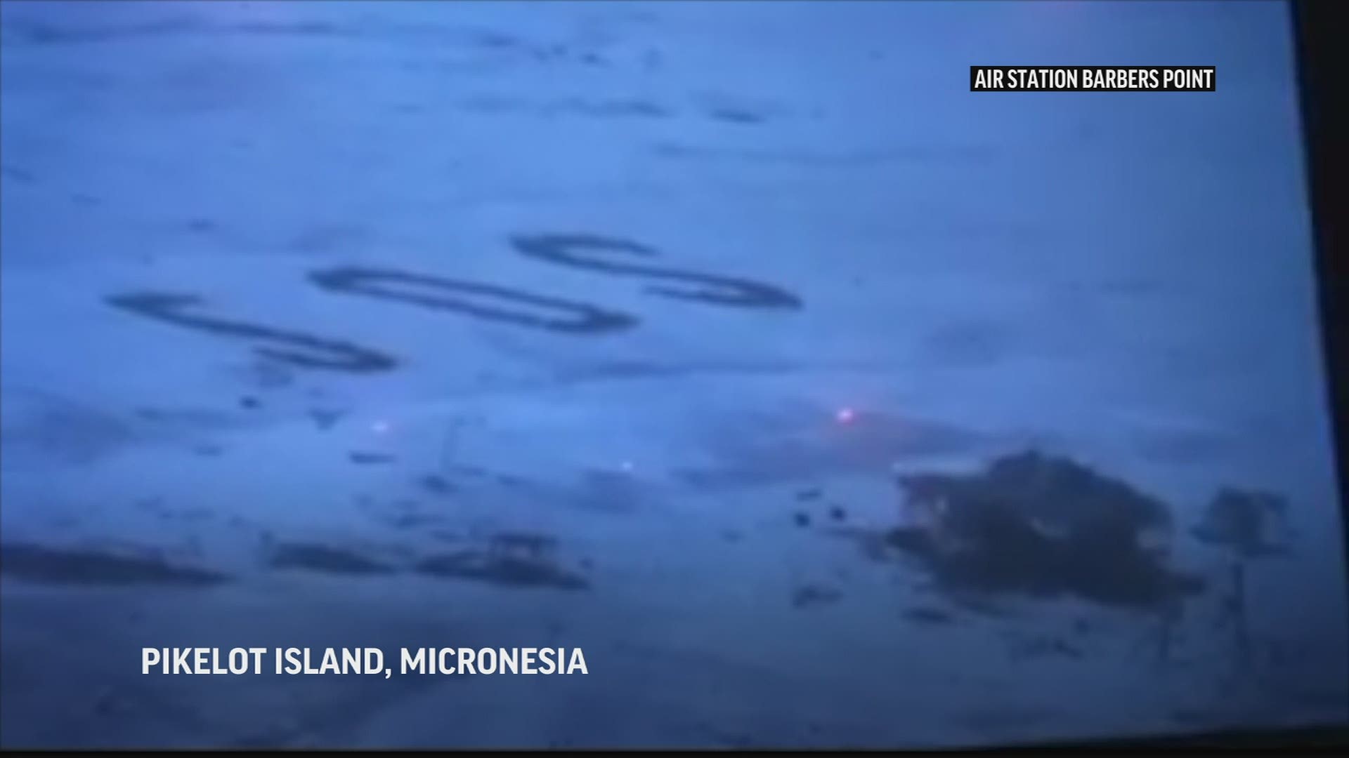 Three men have been rescued from a tiny Pacific island after writing a giant SOS sign in the sand that was spotted from above, authorities say.