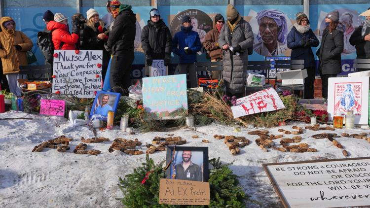 People gather near the scene where Alex Pretti was fatally shot by a U.S. Border Patrol officer yesterday, in Minneapolis, Sunday, Jan. 25, 2026.