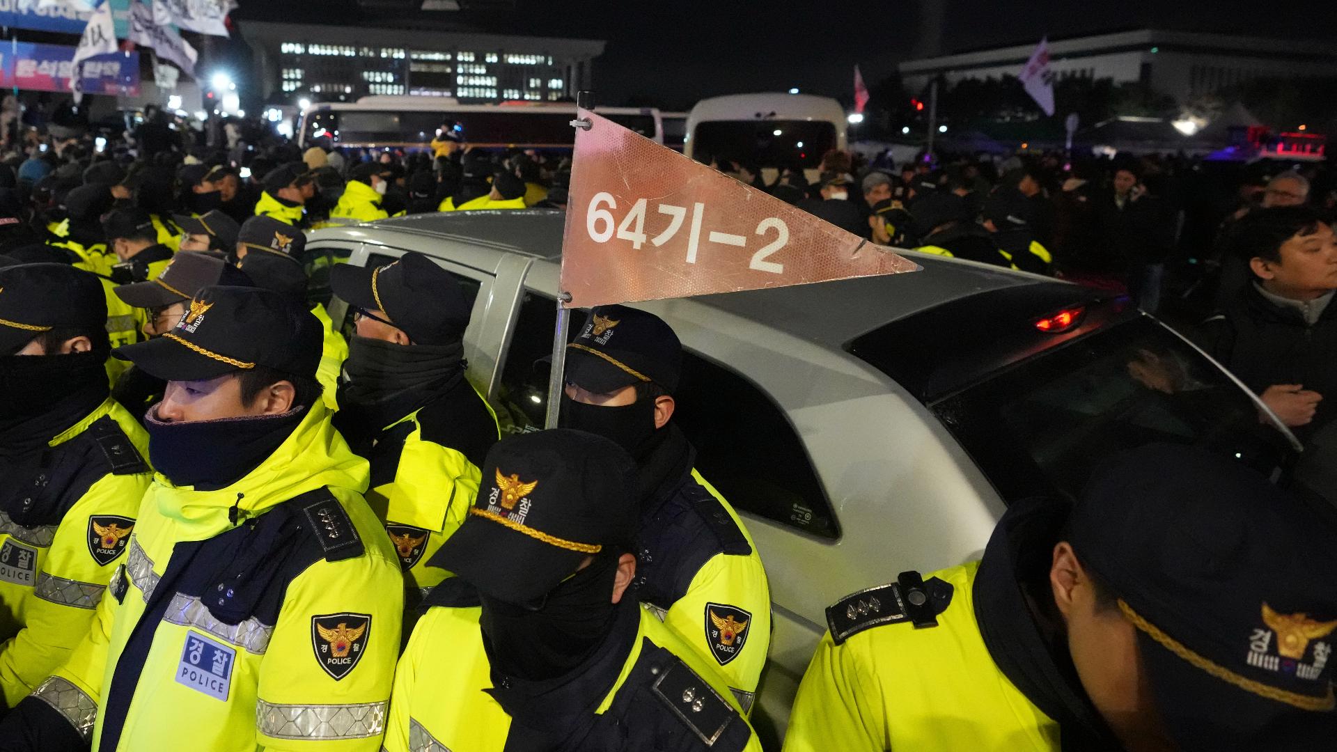 People were seen blocking a military vehicle as it tried to leave an area near South Korea's parliament late Tuesday.