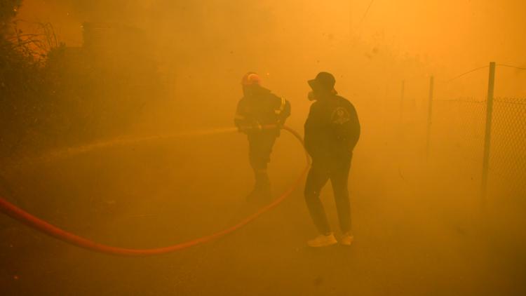 Hundreds of firefighters battle a major wildfire raging out of control on fringes of Greek capital