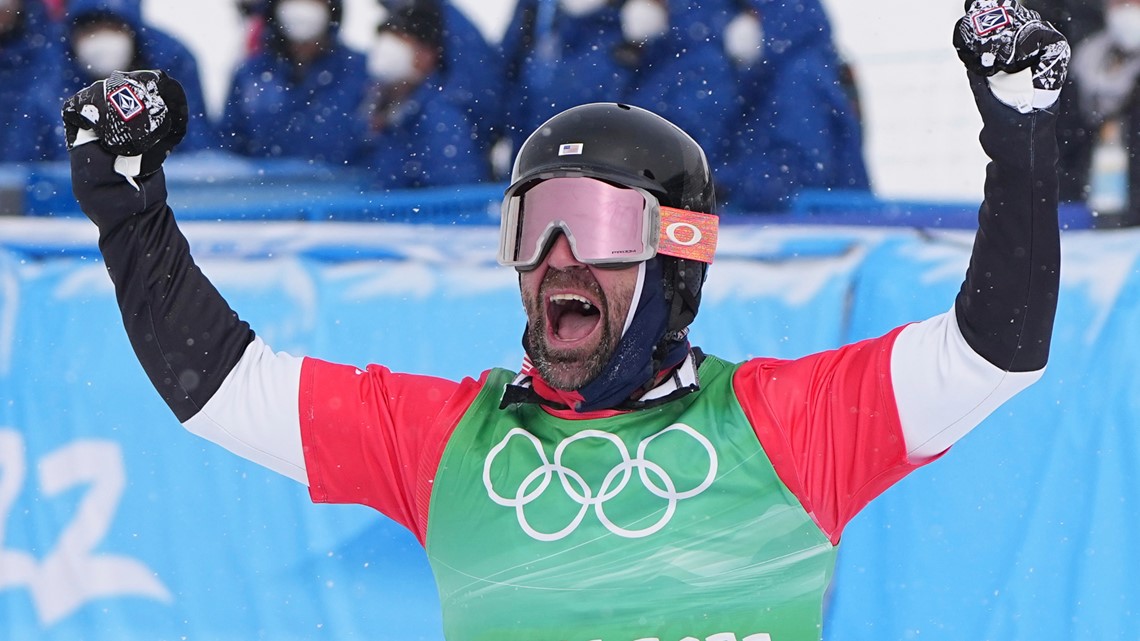 United States' Nick Baumgartner reacts after States' Lindsey Jacobellis, on the ground, crosses the finish line to win a gold medal in the mixed team snowboard cross finals at the 2022 Winter Olympics, Saturday, Feb. 12, 2022, in Zhangjiakou, China. (AP Photo/Gregory Bull)