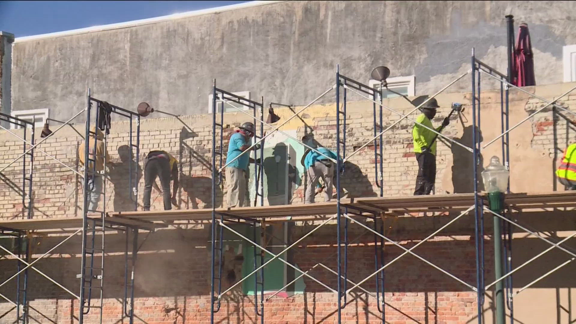 The wall for the greeting mural is chipping and peeling thanks to water.