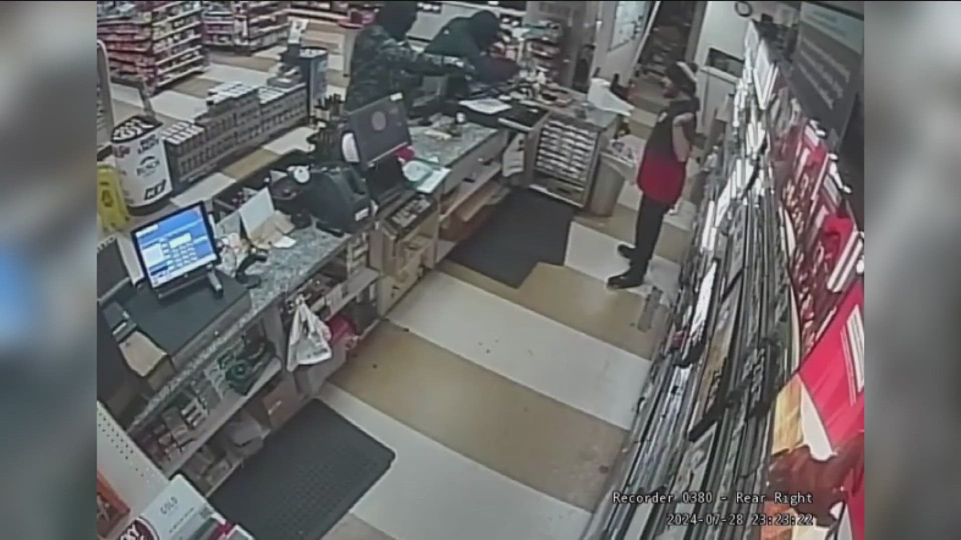 Security camera photos provided by police show one of the men pointing a gun at a cashier.