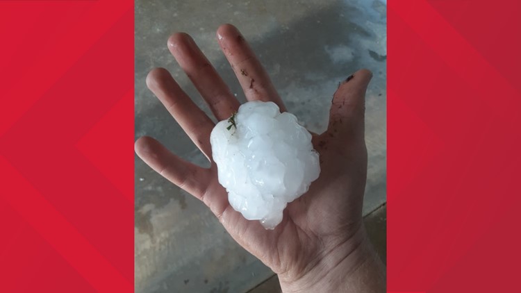 A person holding a handful of hail in their hands photo – Hail
