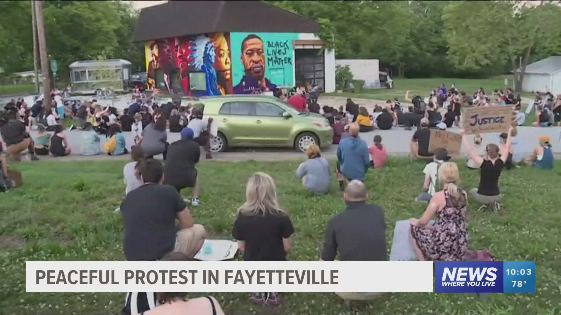 The march ended at the mural of Floyd on 7th Street in Fayetteville where protesters took a knee and sat silently together, hoping for change.