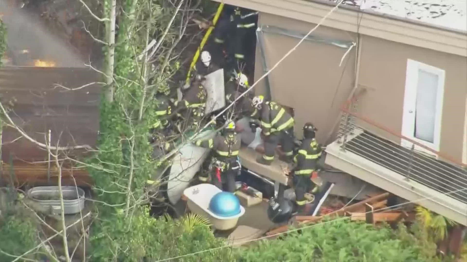 A woman inside the house was able to escape on her own. One dog died and another dog is still unaccounted for, according to the Seattle Fire Department.