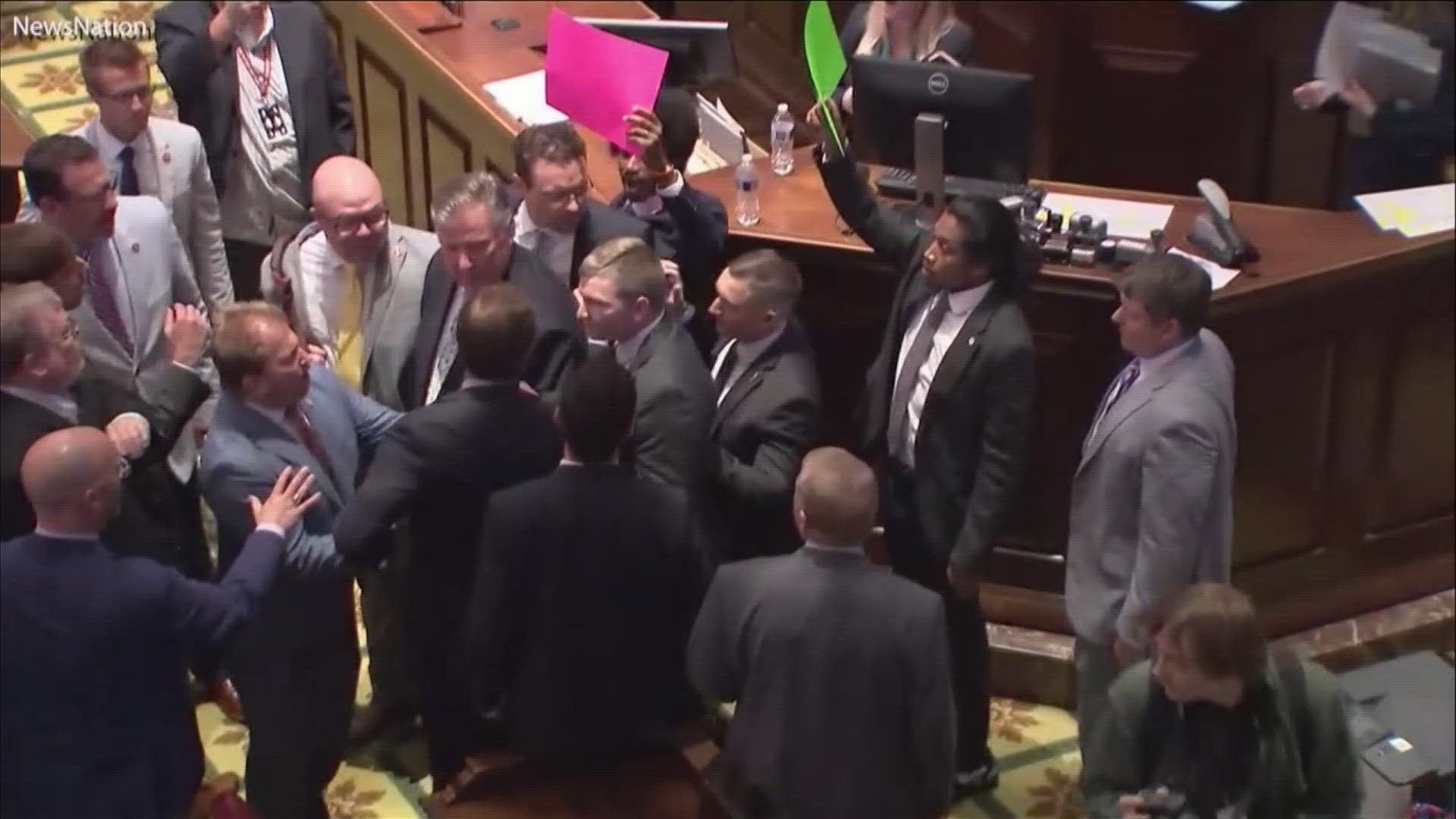 Video captured on the House floor show Sexton making his way out of the House chamber as Pearson approached the speaker's dais holding a sign on gun control.