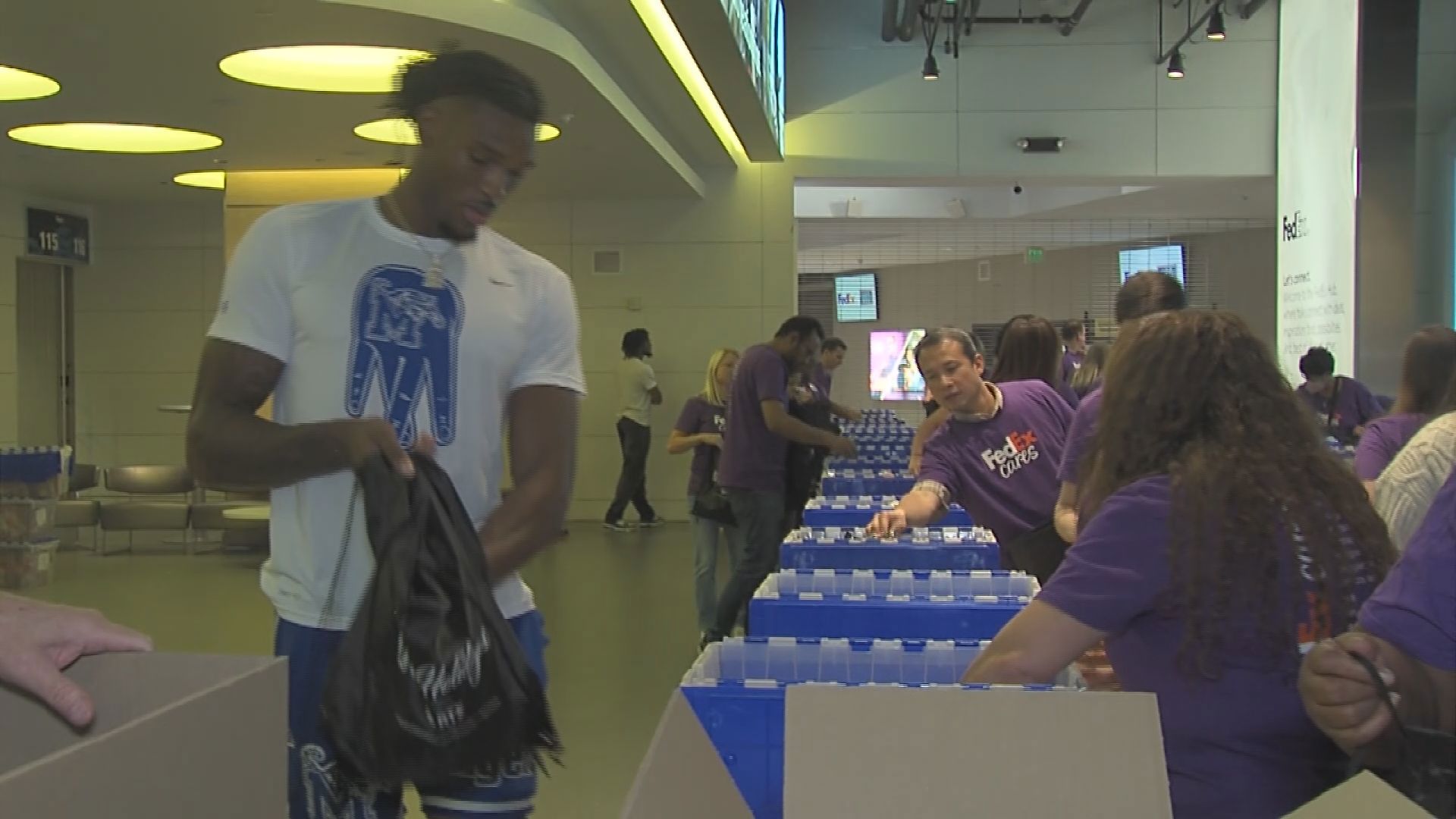 Several Memphis Tiger basketball players were at FedExForum on Wednesday packing holiday care package kits for the troops as part of the FedEx Cares initiative.