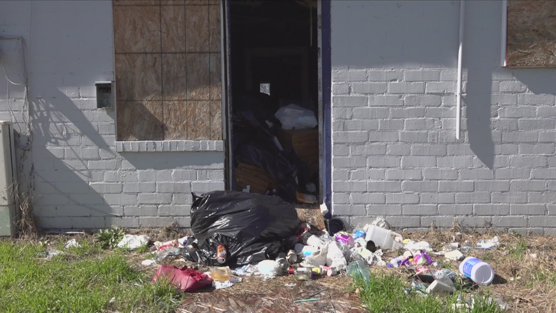 Residents had signs telling them to leave the trash-filled apartment complex, but Code Enforcement denies giving the order.
