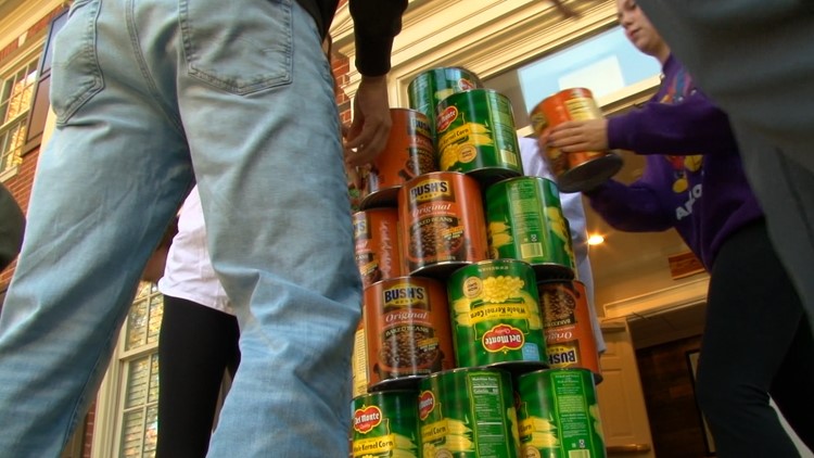 Students compete to stack tallest tower of cans for homecoming, supporting Big Orange Pantry