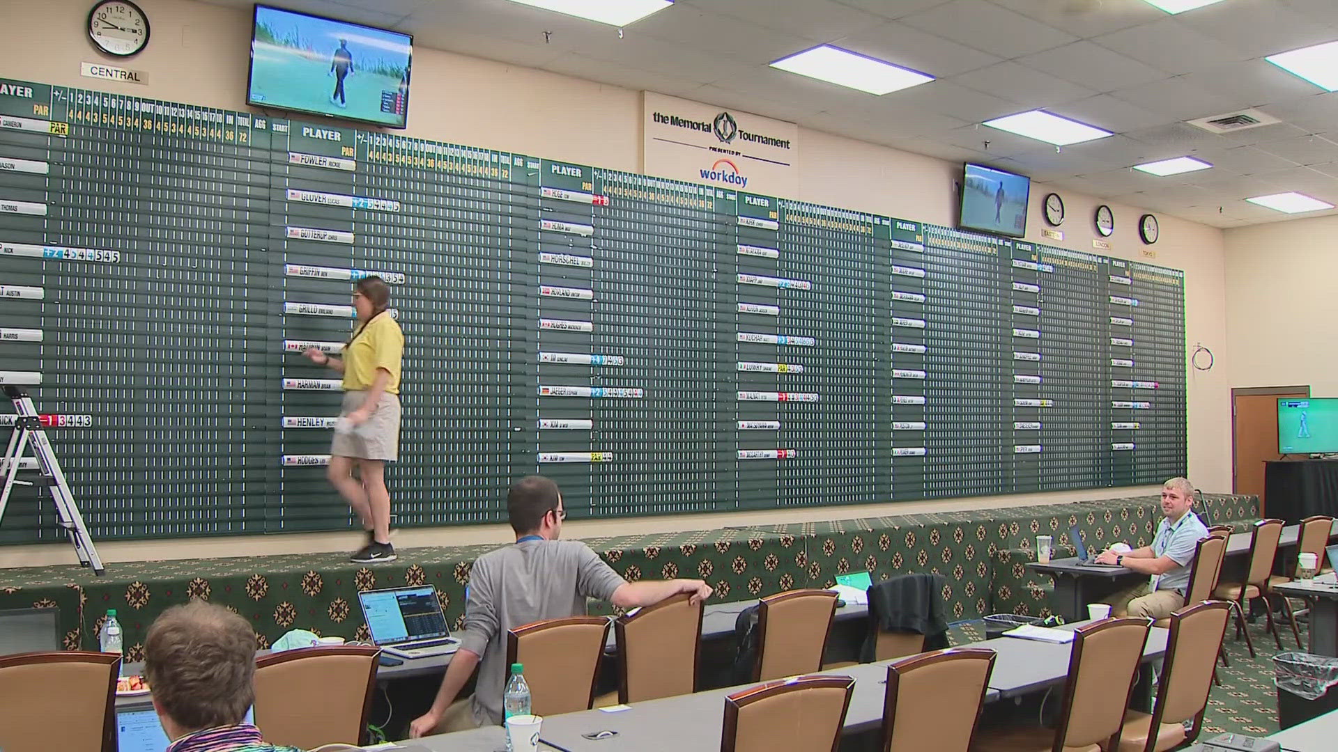 The scoreboard volunteers are busy keeping up with all the golfers playing in the first round.