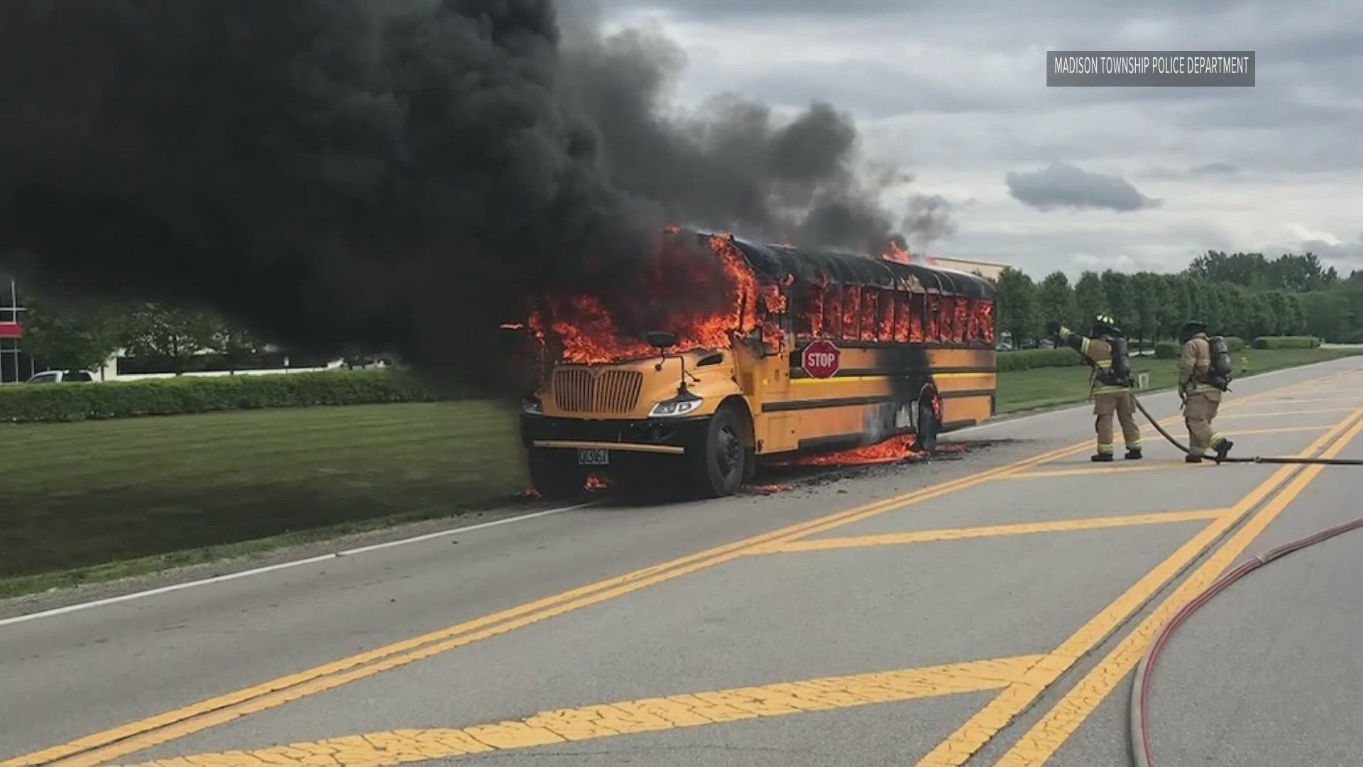 Dashcam video from an officer’s cruiser shows dark, thick smoke engulfing the bus and firefighters working to put it out.