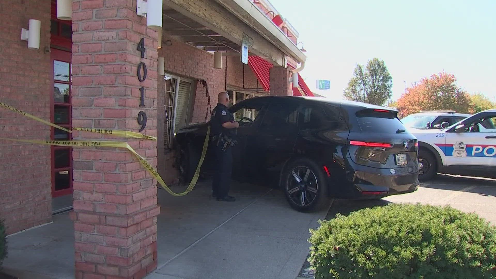 Photos show a black BMW SUV crashed into a window and bricks near the front door of the restaurant.