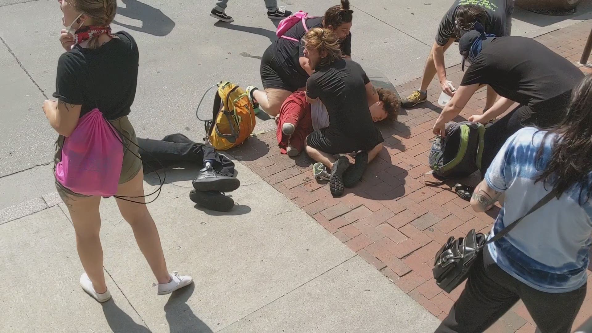 A video that when viral on social media shows a man with prosthetic legs curled on the sidewalk as others care for him and call for a medic.