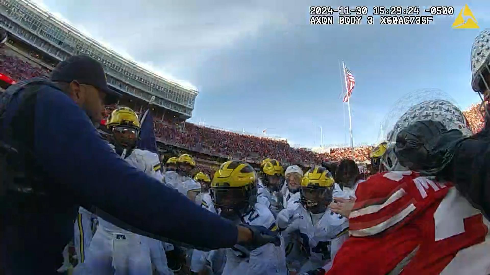 Dozens of officers are seen rushing onto the field trying to get players and staff off each other.