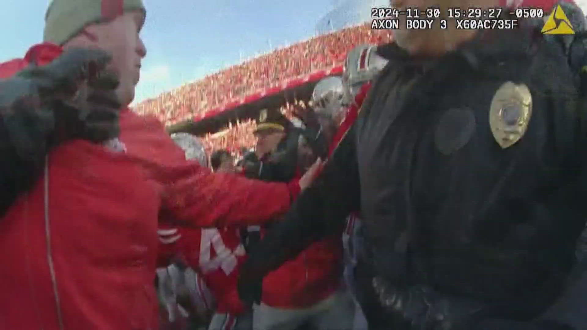 Dozens of officers are seen rushing onto the field trying to get players and staff off each other.