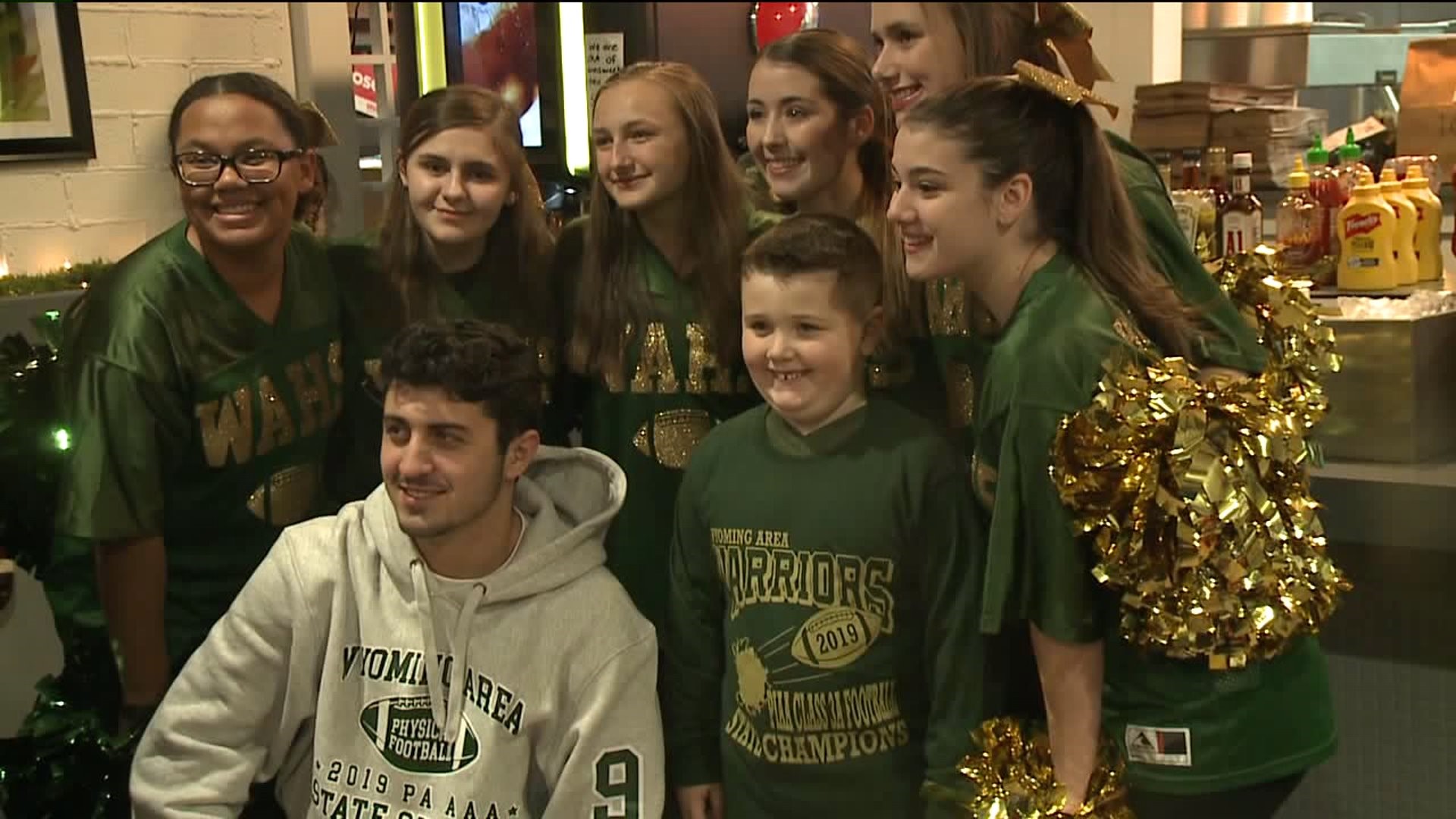 Boy Receives Jersey From Wyoming Area Football Player