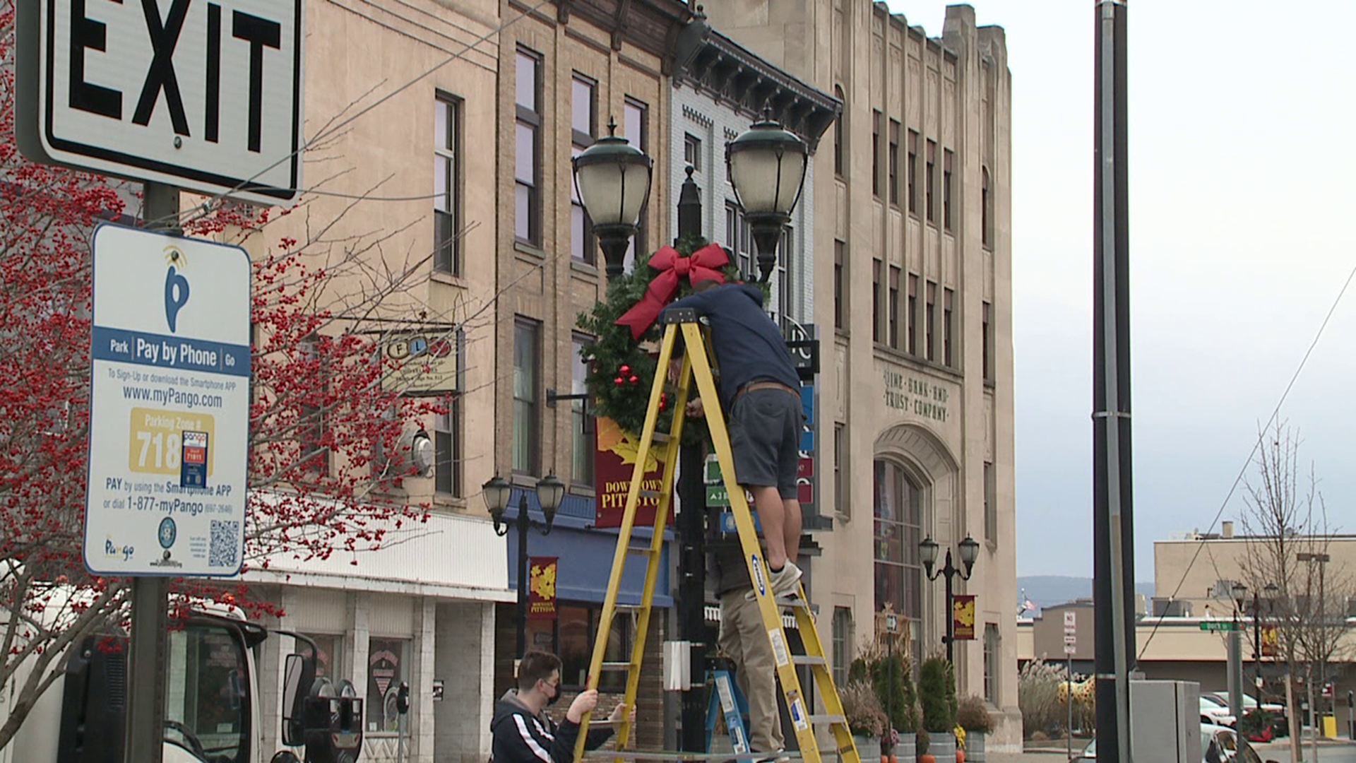 Volunteers worked to place banners and wreaths along Main Street in Pittston Saturday.