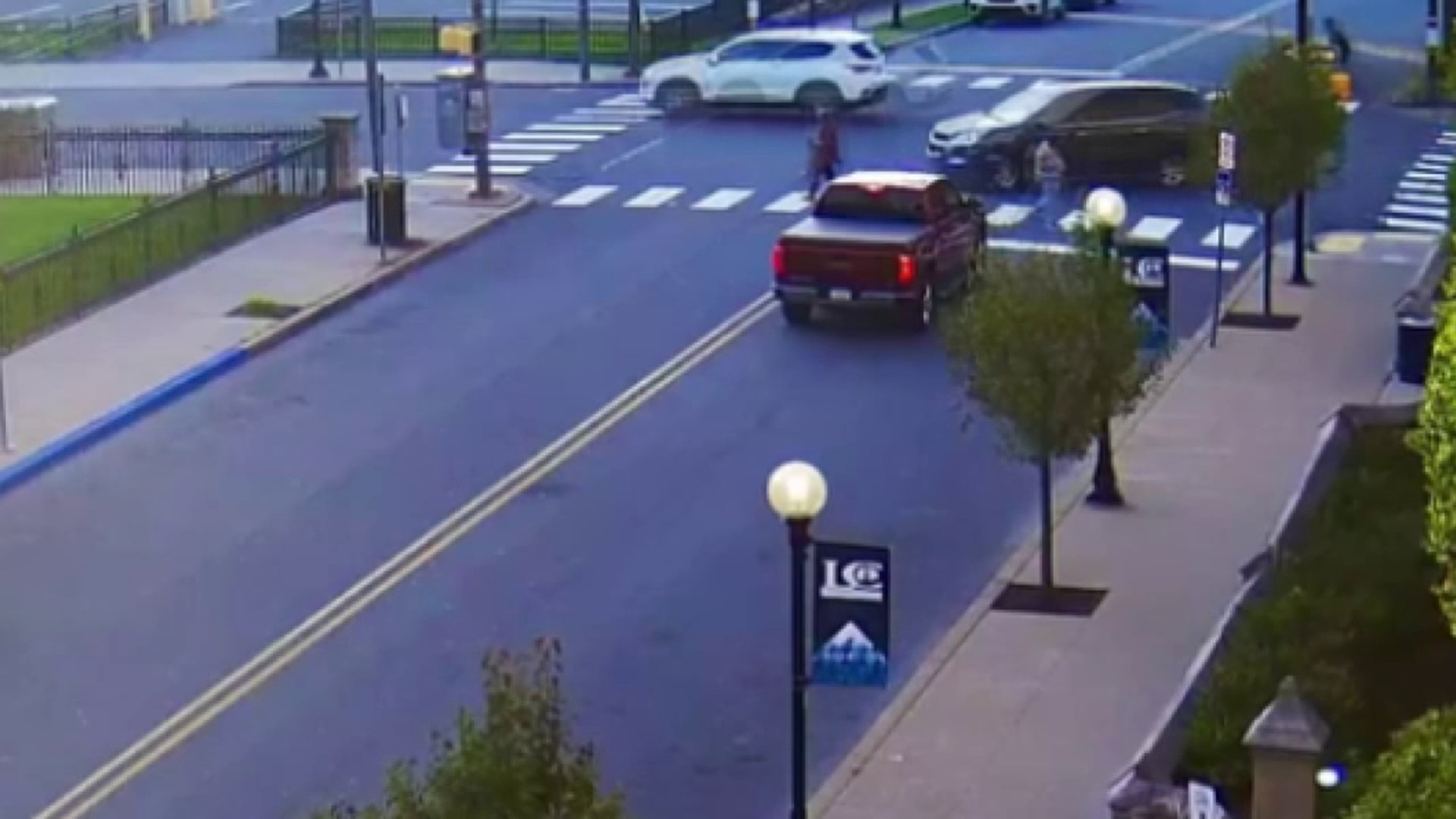 Surveillance video shared by police shows a vehicle strike a pedestrian in a crosswalk.