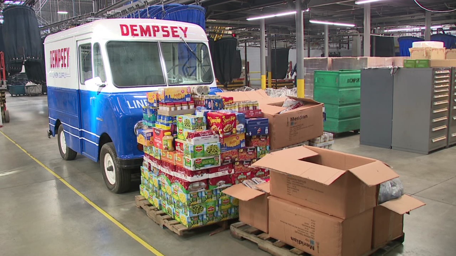 Employees at Dempsey Uniforms & Linen Supply gather food and money in the company's annual initiative and collected over 3,000 pounds of food to donate this year.