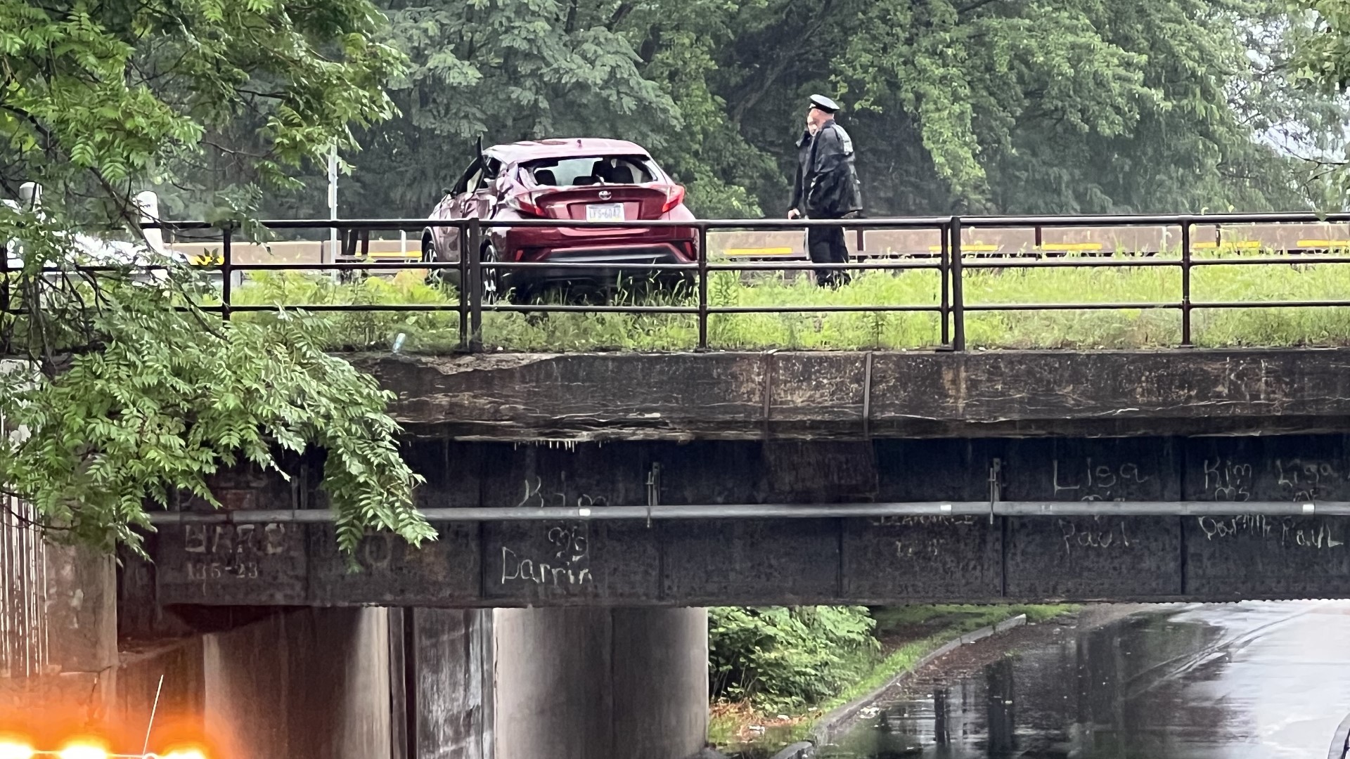 The car rolled over and ended up on a railroad bridge above the road.