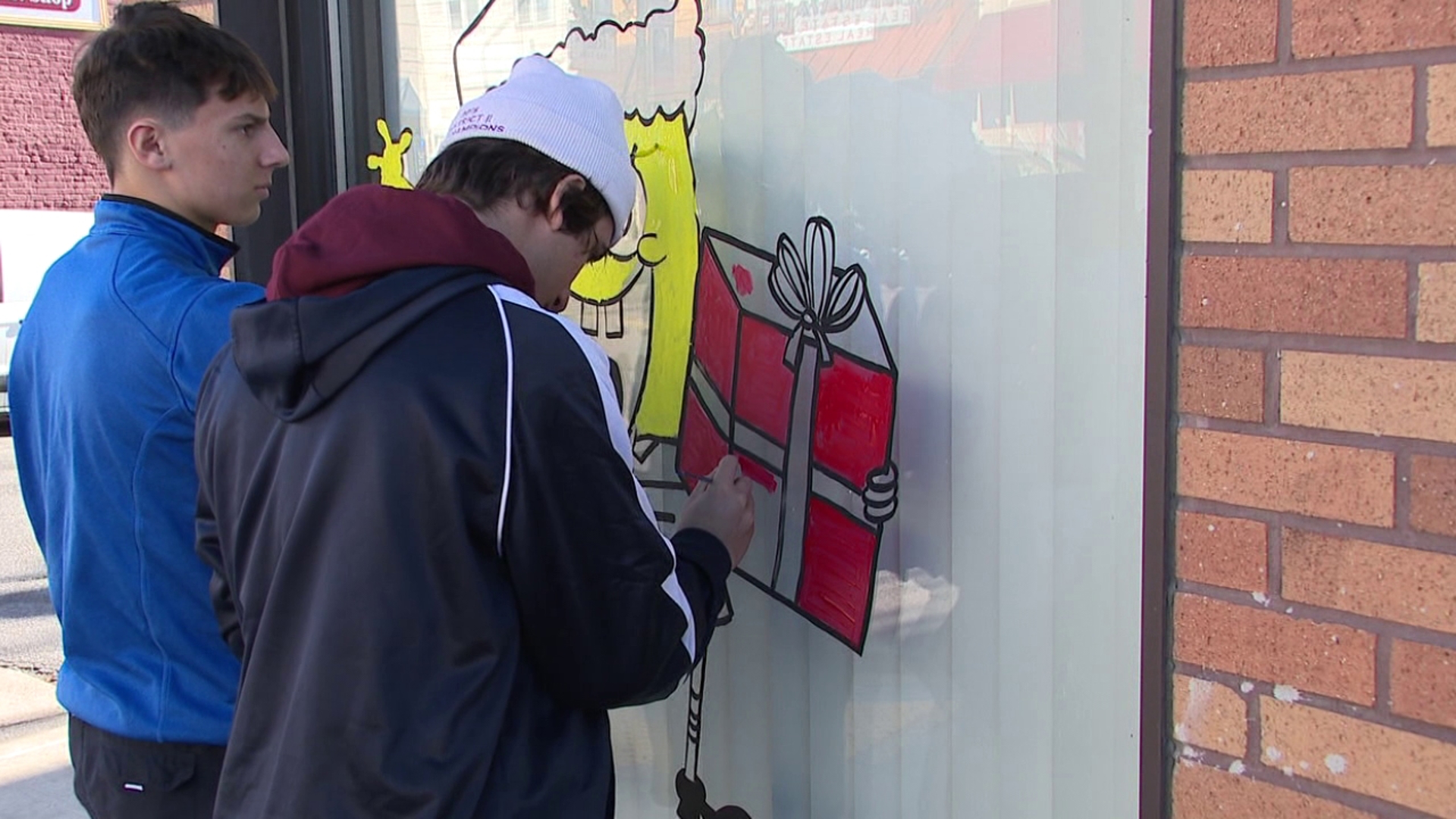 Art students from Dunmore High School get in the Christmas spirit by decorating the borough's storefronts.