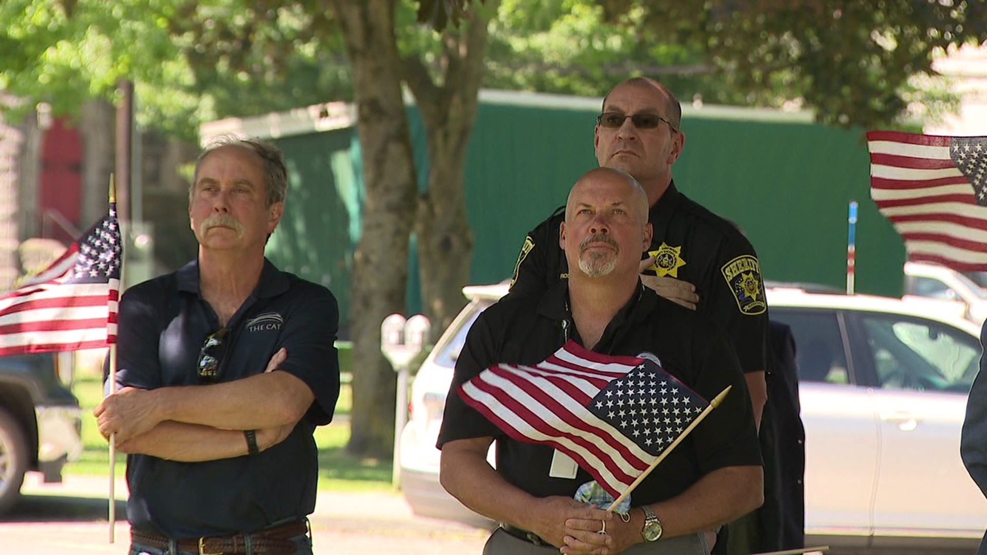 Dozens of county workers handed out flags to adults and children who watched as Old Glory was raised.