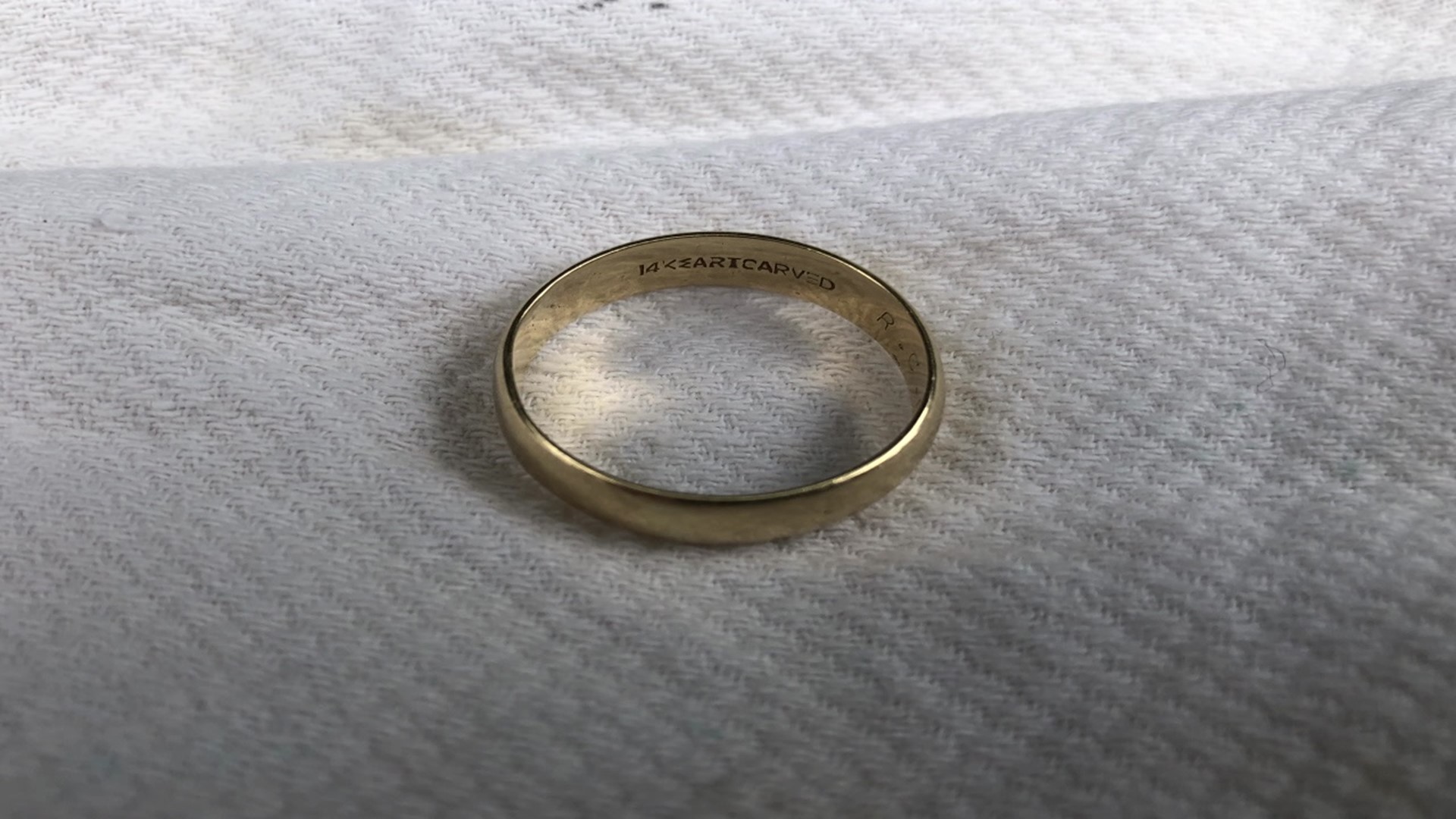 The ring is gold with an engraving on it, and it's believed to be a men's wedding band.