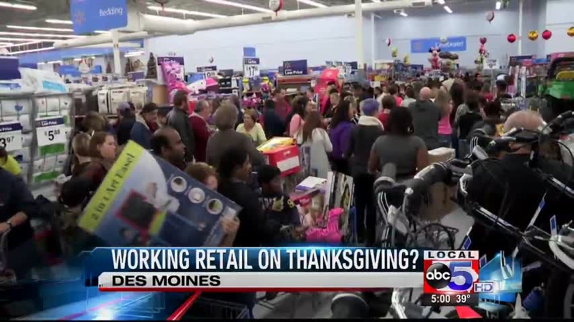 Clothing store worker helps client on black friday, showing new