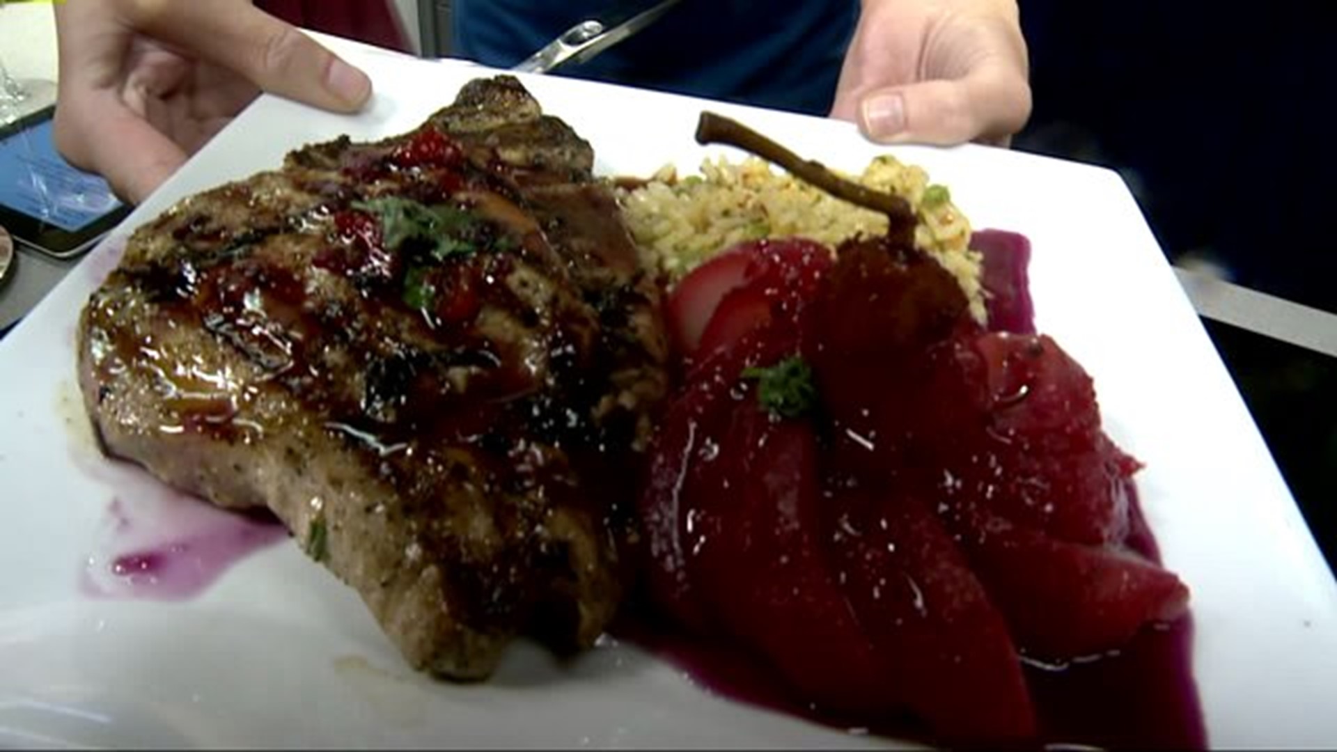Presentation of Fire grilled pork chops served with Poached Hibiscus Pear