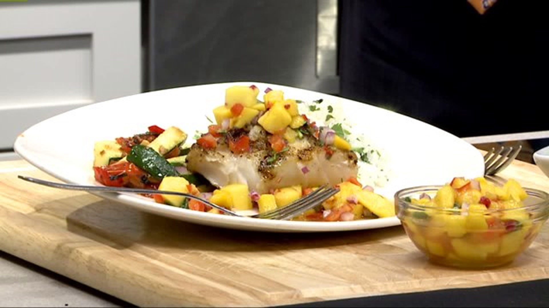 Cooking grilled fish with mango salsa