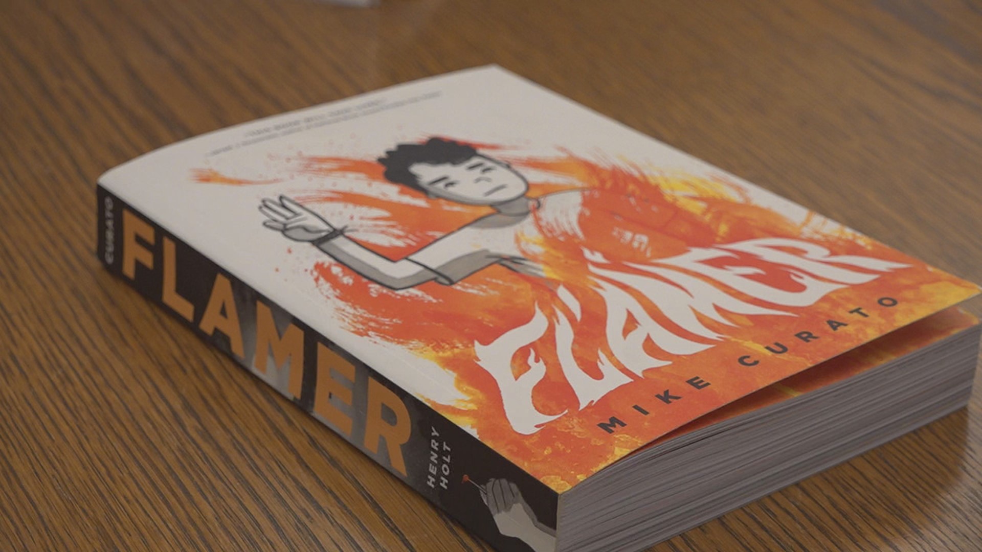 The head librarian at Guthrie Memorial Library promises to keep the book 'Flamer' available after it was pulled from classroom shelves.