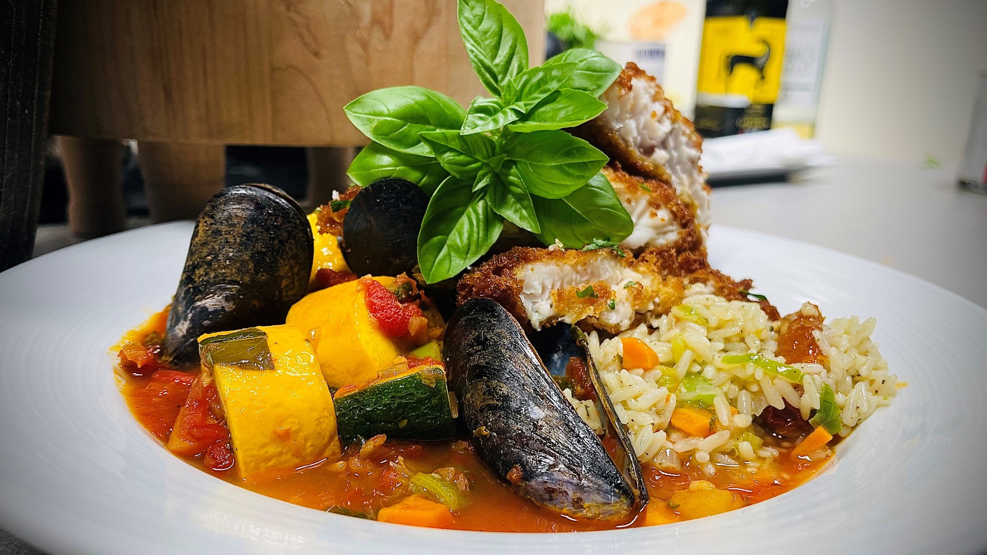 Summer is the season of seafood... and fresh veggies! Olivia's prepares a dish with room for both: crispy catfish served over rice pilaf and garden-style mussels.