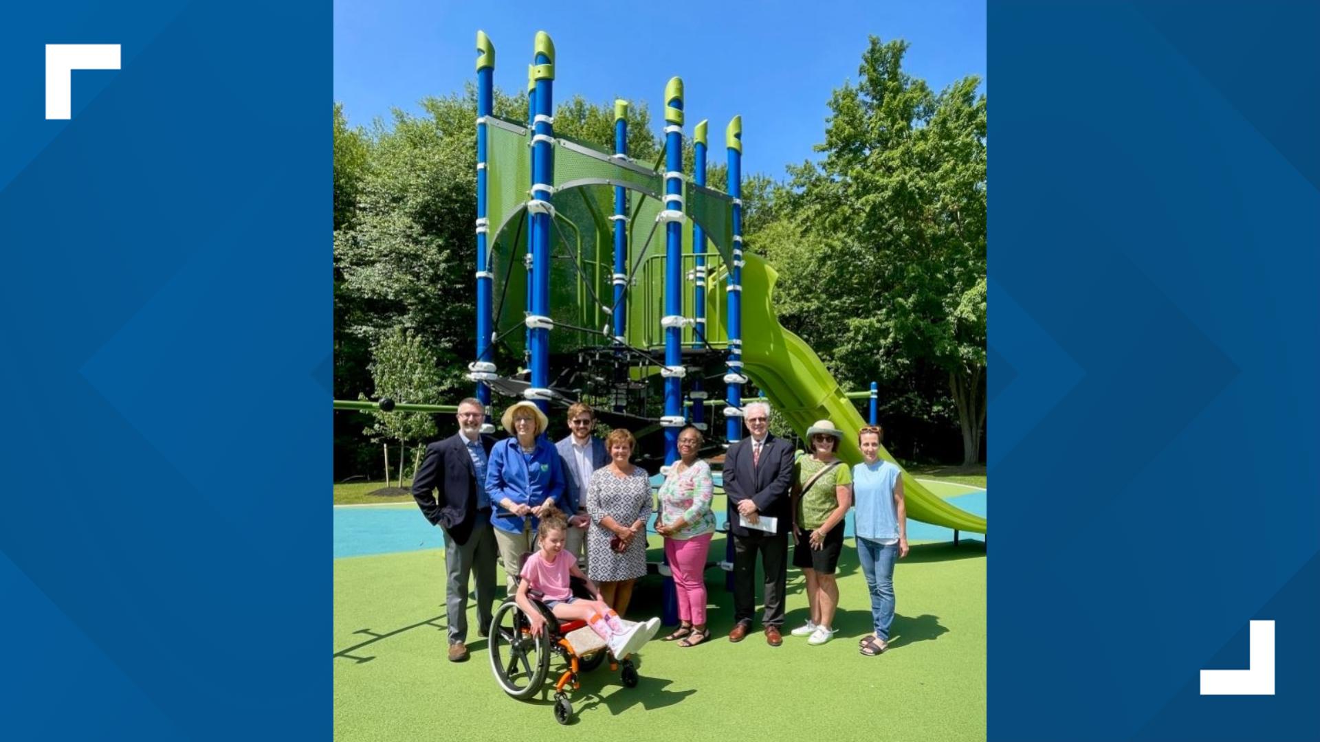 The playground includes areas for children of all ages, a "sound garden," and a paved path leading to a nearby walking area, among other features.