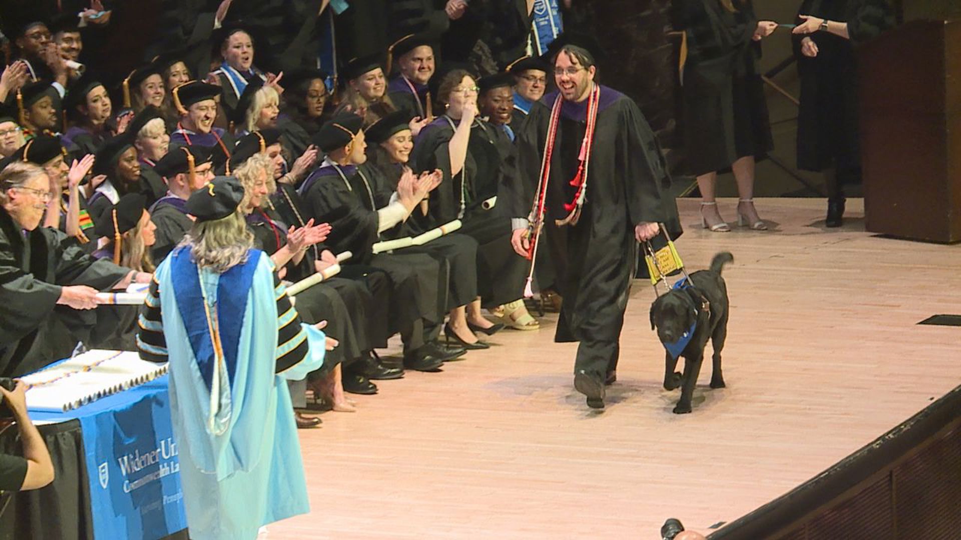Zachary Penzone, who has retinitis pigmentosa, was joined on stage by his seeing-eye dog on graduation day.