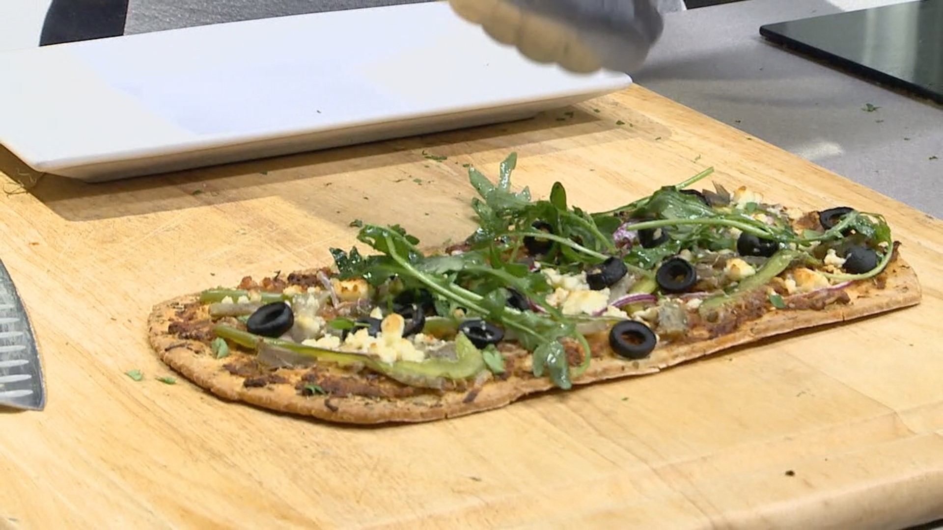 Artichokes are in season, and Andrea Michaels shows us how to prepare them from scratch. They are paired with seasonal arugula in a Mediterranean flatbread.