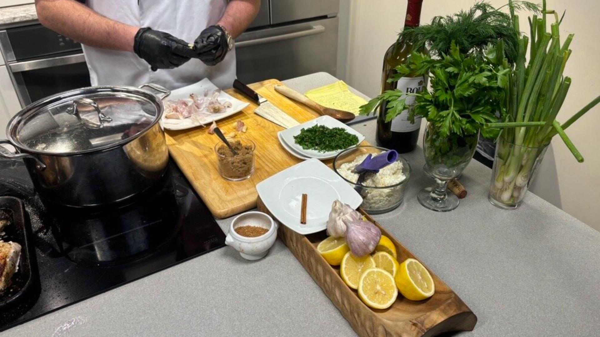 Fire-grilled pork chops are topped with a Greek Style Chimichurri and served with Greek style beans and potatoes.