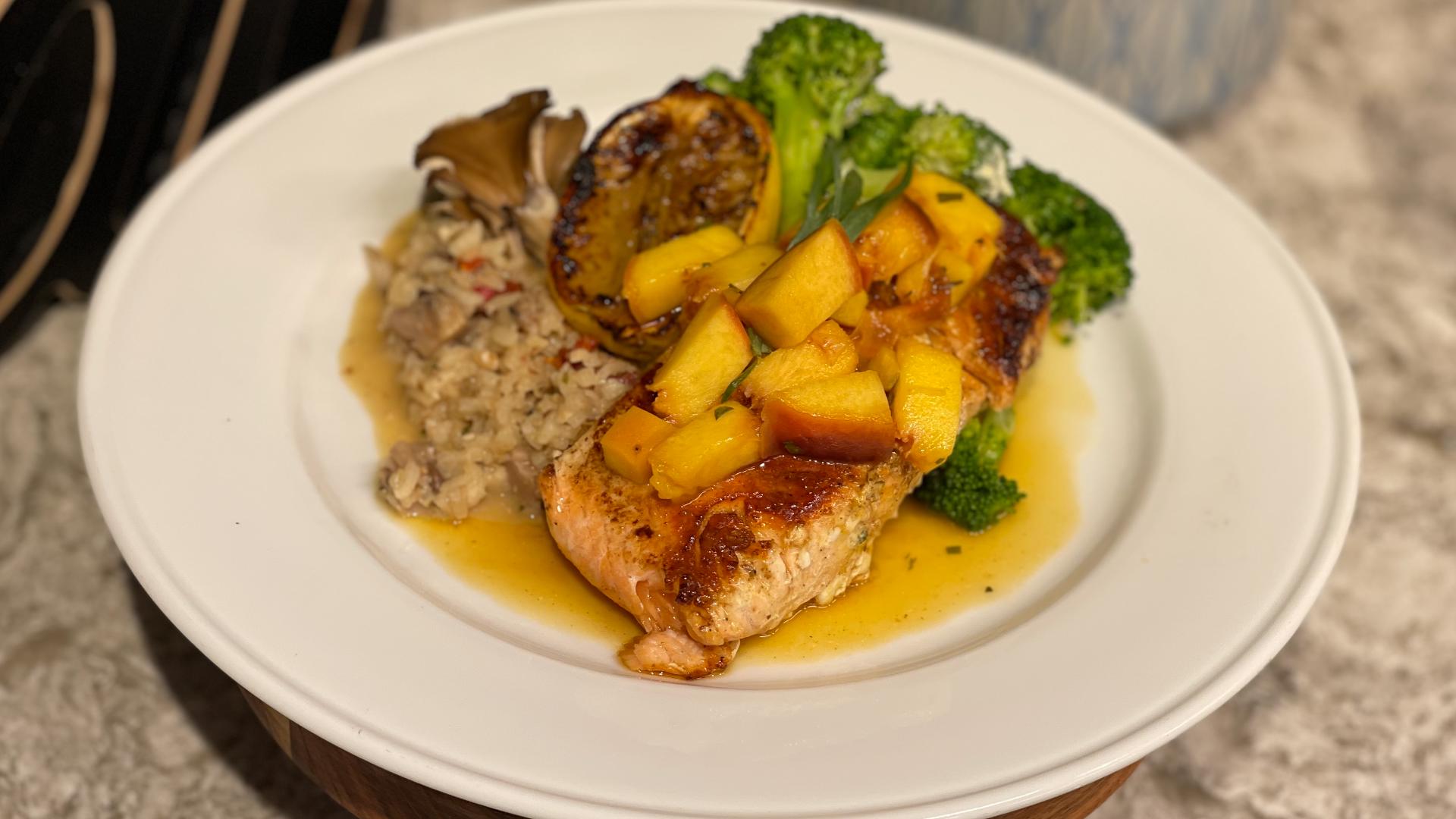 Grilled salmon is served over toasted Walnut and Wild Mushroom Risotto along with steamed broccoli. Everything then gets topped with a fresh Honey Peach Chutney.