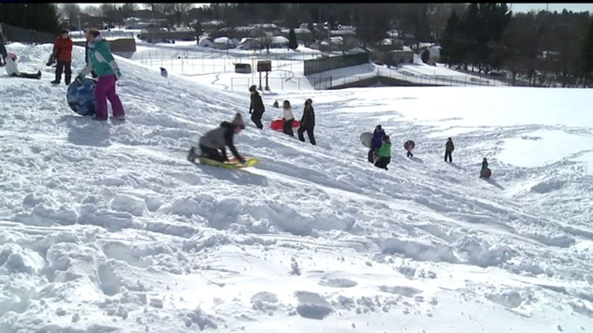 Children sled down hills in the snow