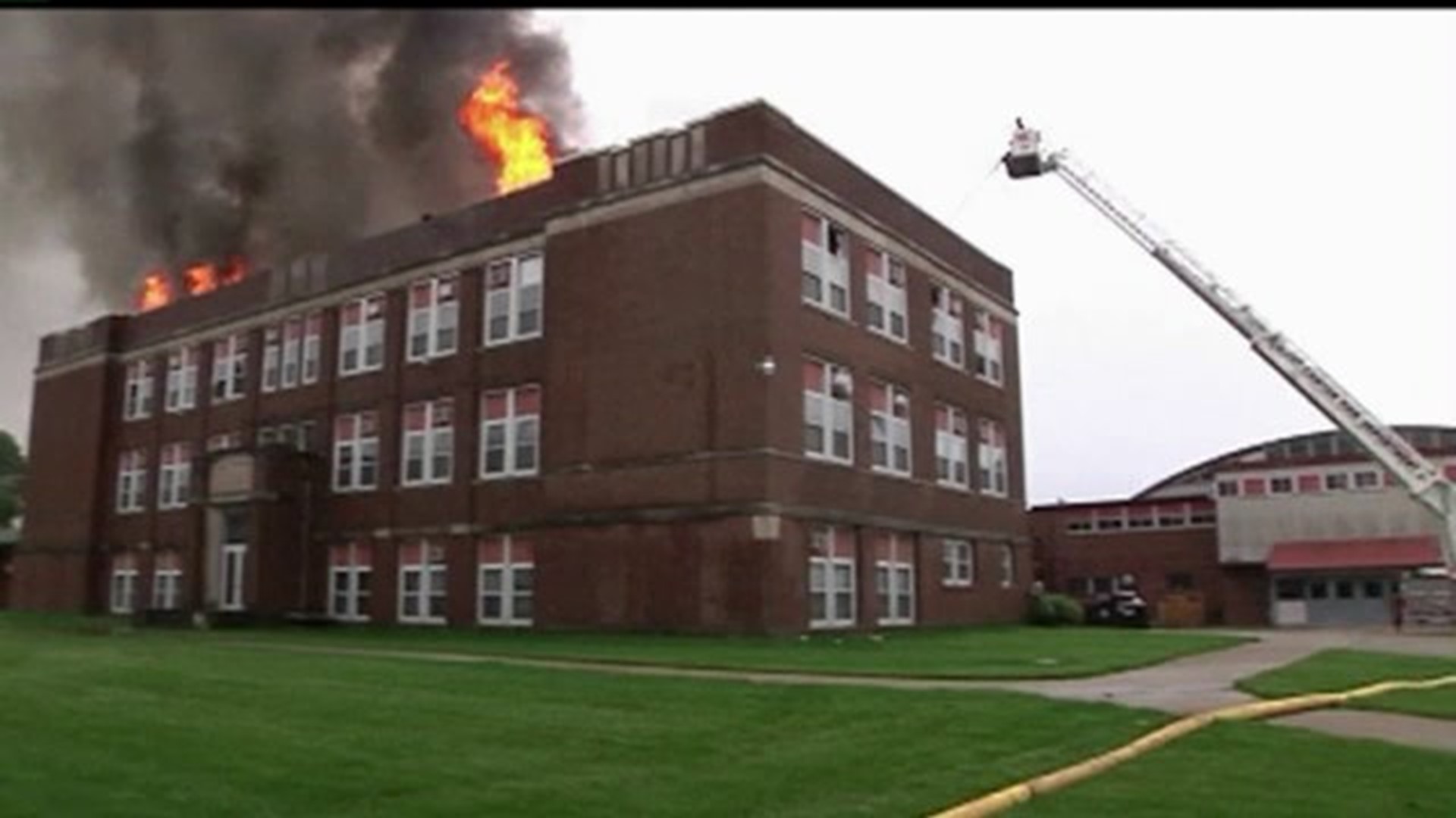 Flames shoot through roof of former school building