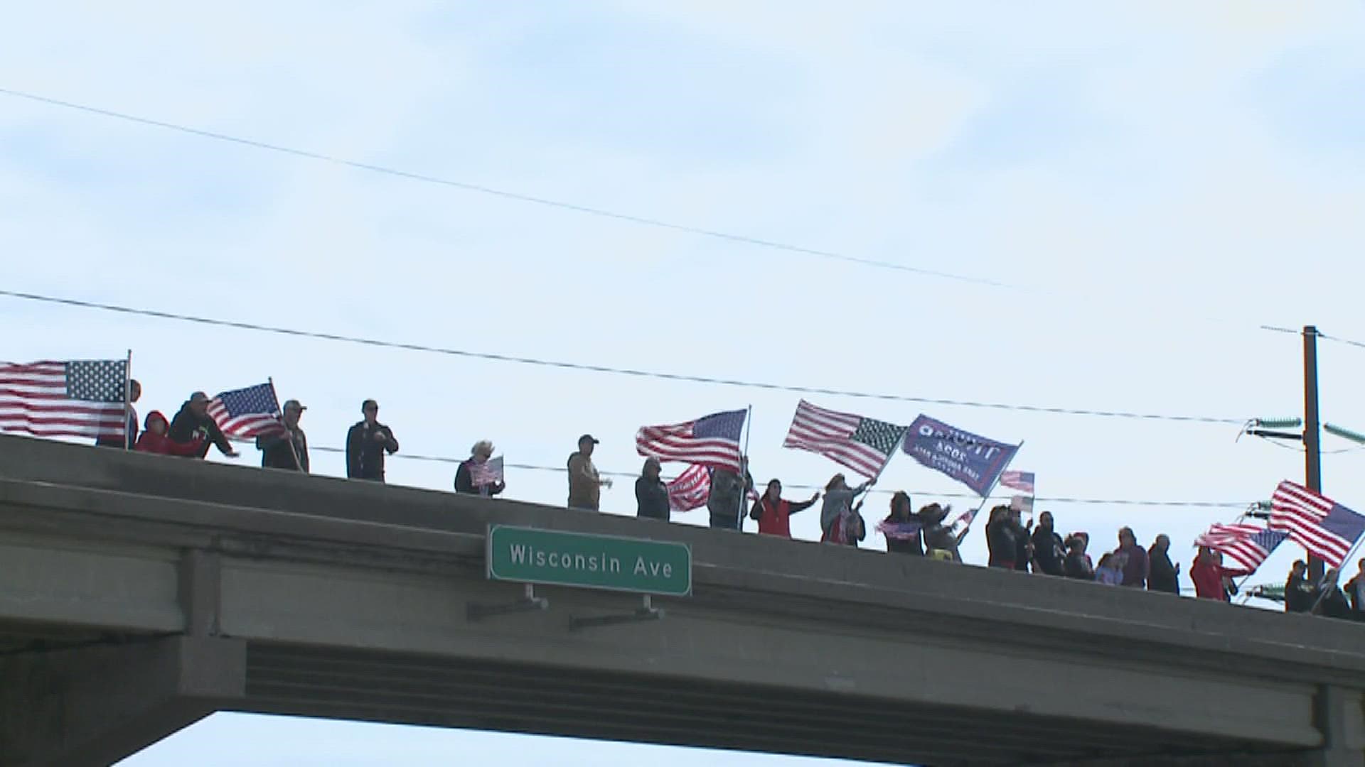 Hundreds of people stood on bridges across I-80 on Saturday  to support truckers protesting government mandates on their way to Washington D.C.