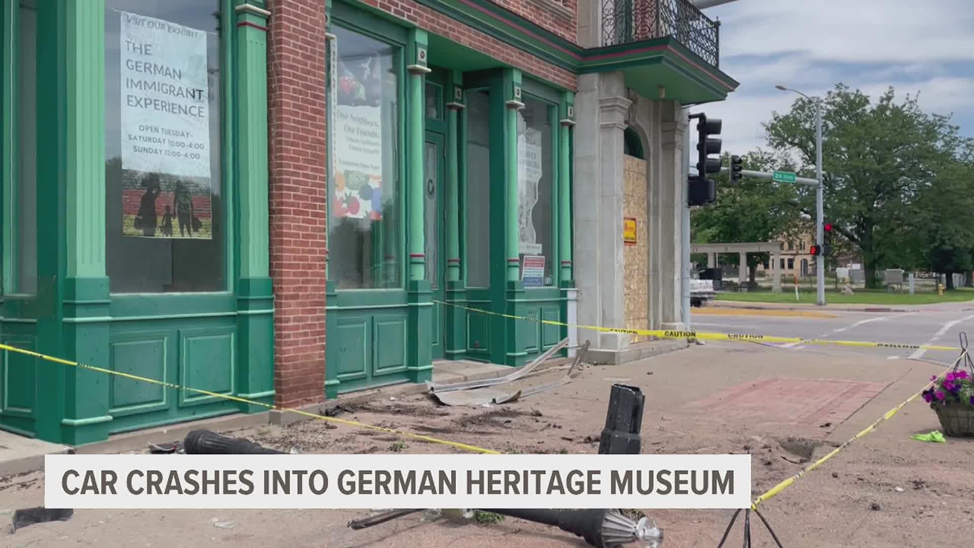 Glass and a fallen sign littered the sidewalk outside the German American Heritage Center after a crash early Sunday.