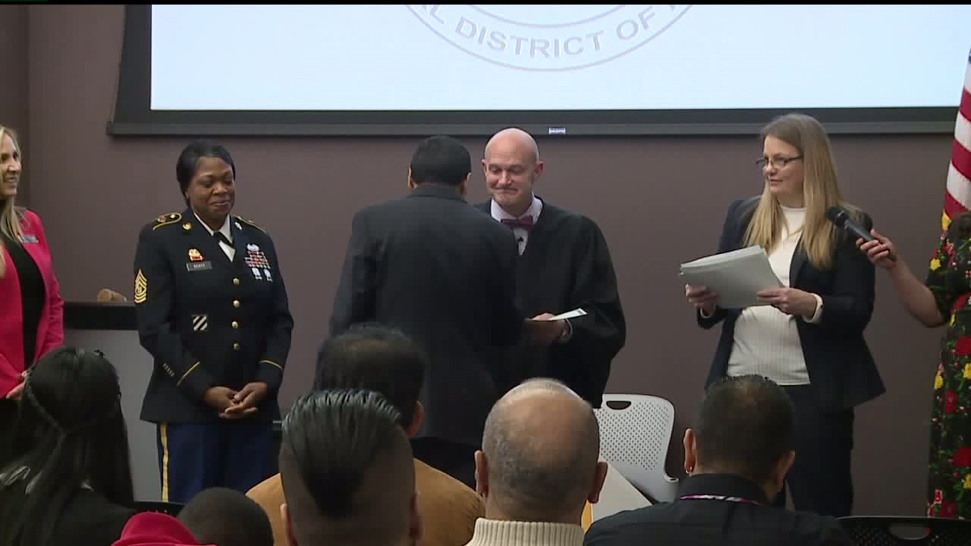 Dozens of immigrants become naturalized citizens at ceremony