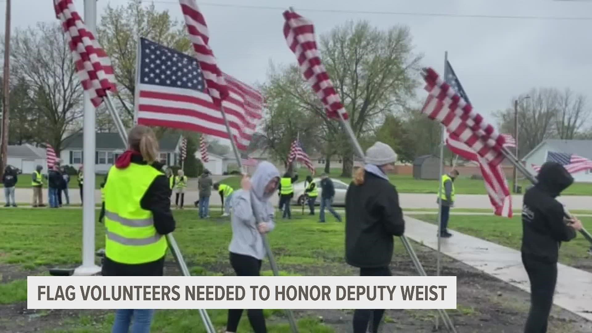 The public was asked to help set up flags outside of Galesburg High School before Saturday's memorial service for Deputy Nicholas Weist.