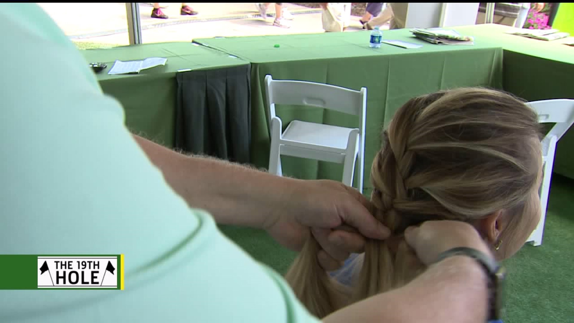 Caddie helps volunteers by French braiding their hair