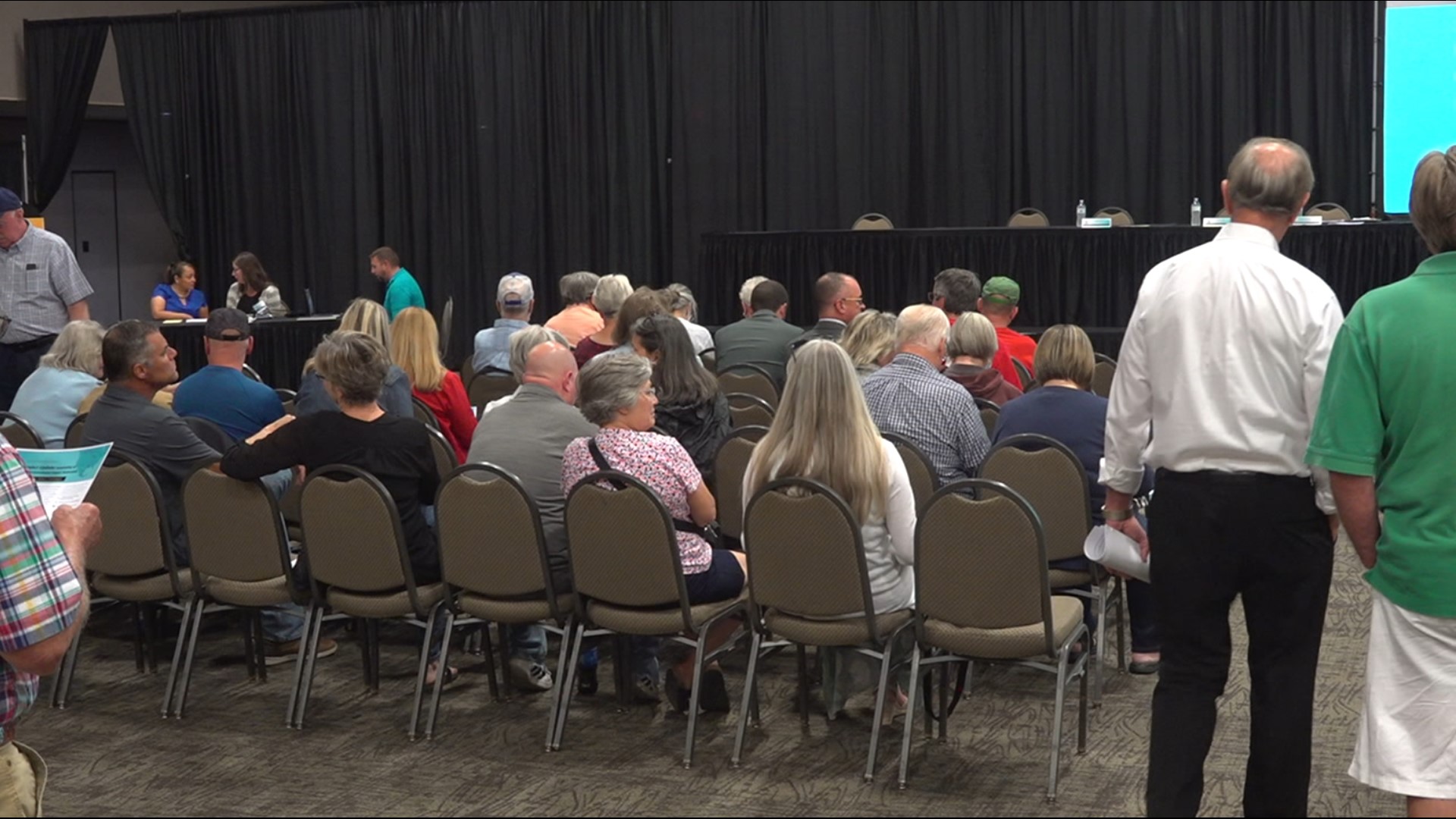 Community members took their turn at the mic to share their concerns about the possible Canadian Pacific - Kansas City Southern rail merger in a Davenport meeting.