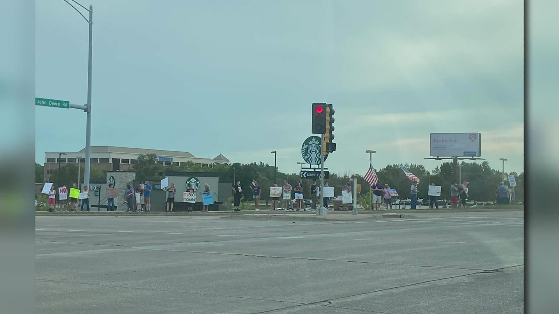 Over 100 people met near UnityPoint Health - Trinity in Moline to protest mandated vaccines for healthcare workers, saying it should be a personal choice.