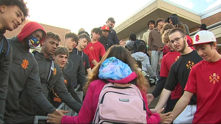 High fives and fist bumps: Men gather to greet Rock Island Academy students
