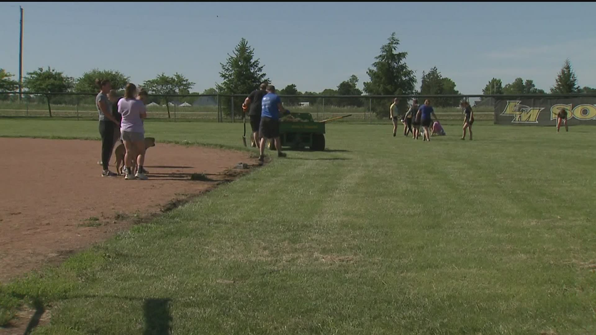 Players, Coaches and Parents help get the softball field ready to play at Louisa-Muscatine.
